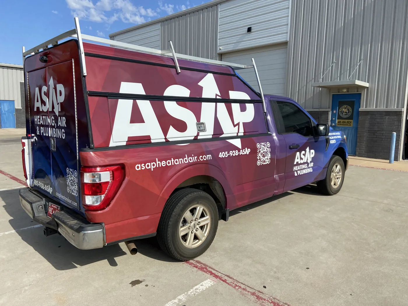 Rear three-quarter view of the ASAP F-150 wrap, with the topper door wrapped in the same design