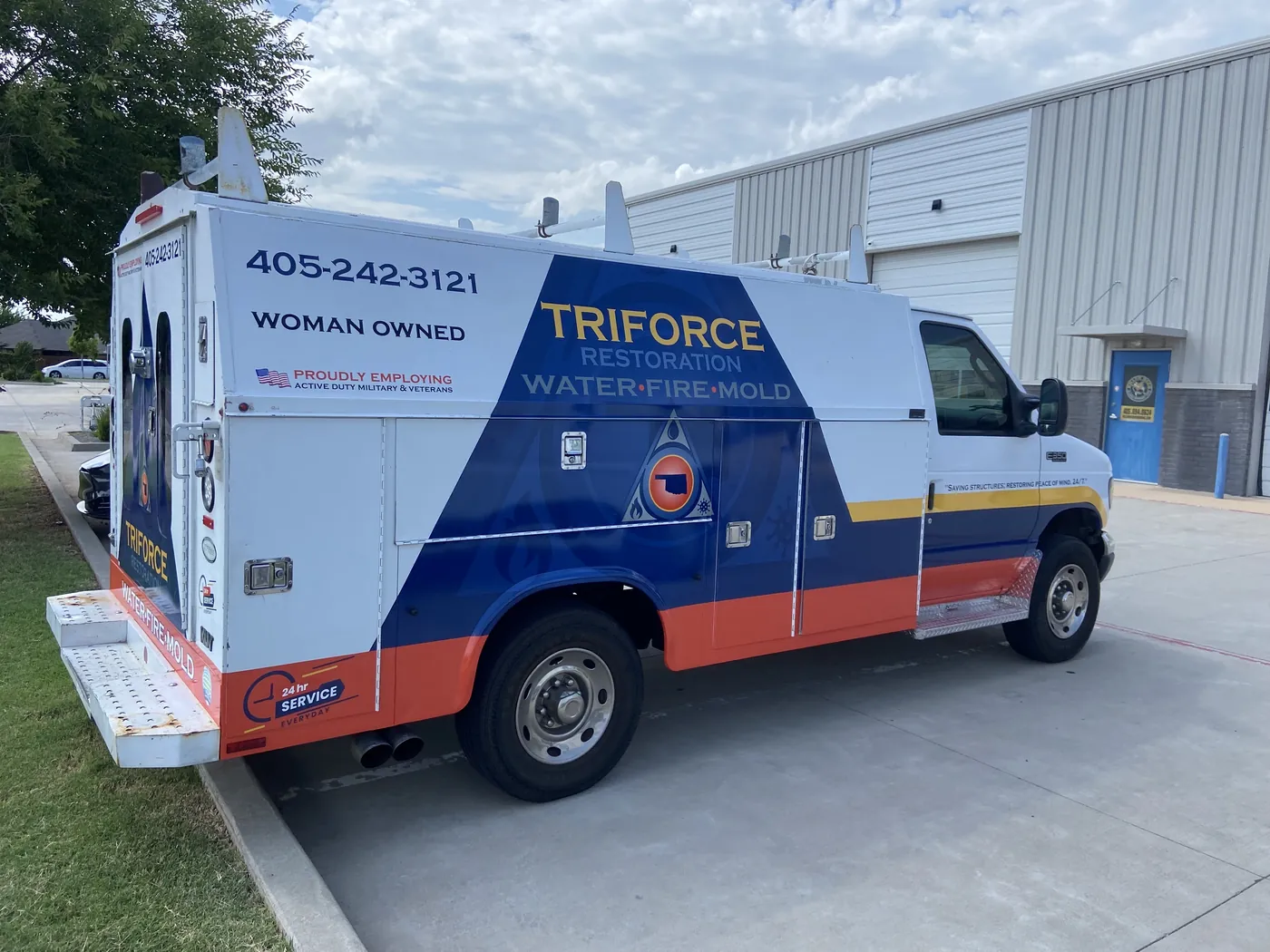 Triforce Restoration Ford E-350 service body truck with a red, white, and blue partial wrap and a large blue triangle logo panel, wrapped by Wrap It Up in Edmond OK